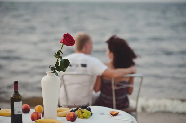 Счастливая пара пьет шампанское с игристым вином на празднике расслабляющей вечеринки на пляже — стоковое фото
