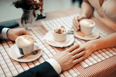 Çift kahve içiyor. Evli çift el ele tutuşarak closeup görünümü