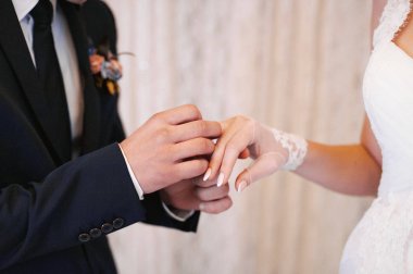 Halkaları koyarak. Gelin ve damat yüzük elbise
