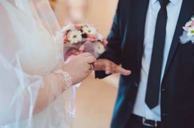 Halkaları koyarak. Gelin ve damat yüzük elbise