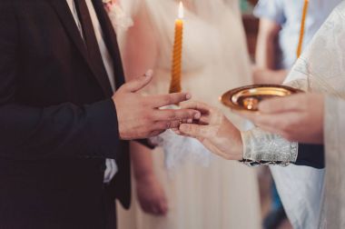 Halkaları koyarak. Gelin ve damat yüzük elbise