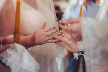 Halkaları koyarak. Gelin ve damat yüzük elbise