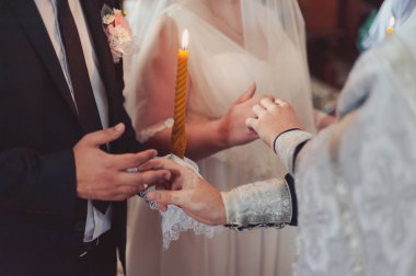 Halkaları koyarak. Gelin ve damat yüzük elbise