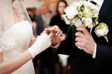 Halkaları koyarak. Gelin ve damat yüzük elbise