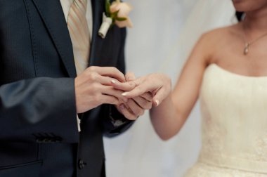 Halkaları koyarak. Gelin ve damat yüzük elbise