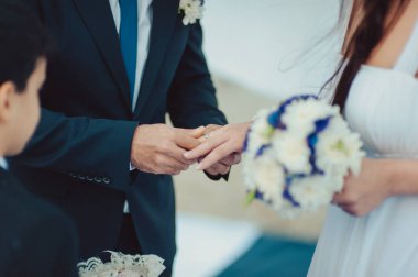 Halkaları koyarak. Gelin ve damat yüzük elbise