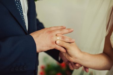 Halkaları koyarak. Gelin ve damat yüzük elbise