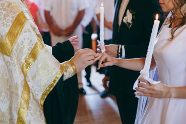 Halkaları koyarak. Gelin ve damat yüzük elbise