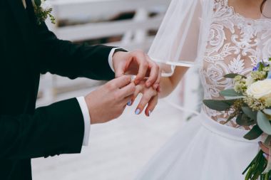 Halkaları koyarak. Gelin ve damat yüzük elbise