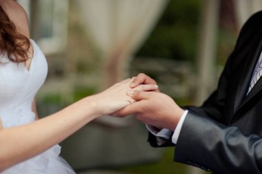 Halkaları koyarak. Gelin ve damat yüzük elbise