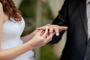 Halkaları koyarak. Gelin ve damat yüzük elbise