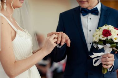 Halkaları koyarak. Gelin ve damat yüzük elbise