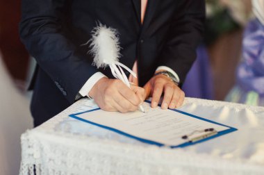 İmza töreni. Gelin ve damat evlilik hakkında belgeleri imzalayın