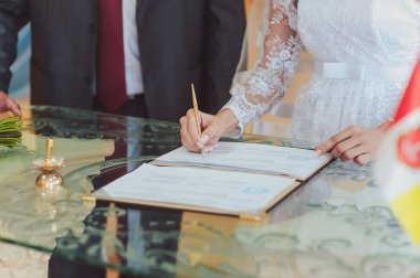 İmza töreni. Gelin ve damat evlilik hakkında belgeleri imzalayın