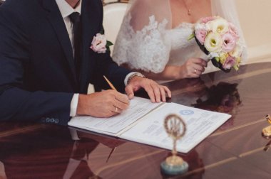 İmza töreni. Gelin ve damat evlilik hakkında belgeleri imzalayın