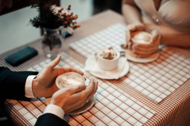 Çift kahve içiyor. Evli çift el ele tutuşarak closeup görünümü