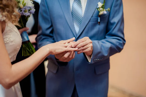 Uvedení na kroužky. Nevěsta a ženich šaty kroužky — Stock fotografie