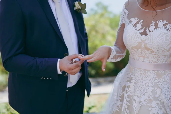 Halkaları koyarak. Gelin ve damat yüzük elbise — Stok fotoğraf