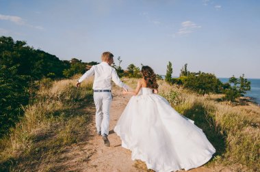 Deniz kenarında yürüyüşe güzel düğün çifti