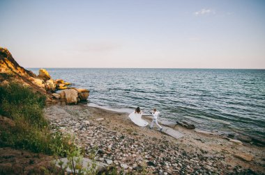 Deniz kenarında yürüyüşe güzel düğün çifti
