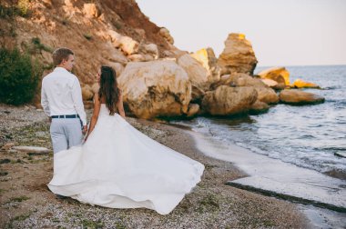 Deniz kenarında yürüyüşe güzel düğün çifti