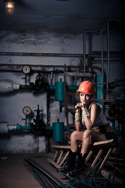 Hermosa chica con un casco en la sala de calderas — Foto de Stock