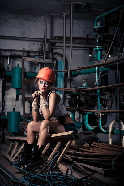 Hermosa chica con un casco en la sala de calderas — Foto de Stock