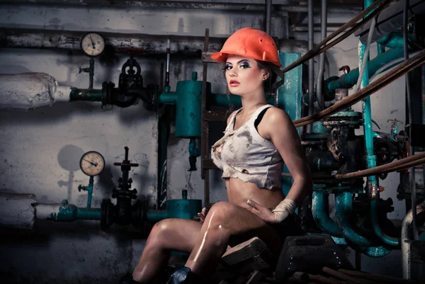 Hermosa chica con un casco en la sala de calderas — Foto de Stock