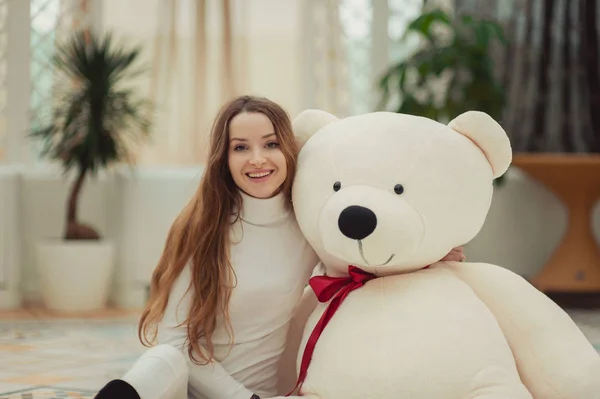 Krásná dívka drží velký bílý medvídek — Stock fotografie