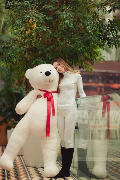 Όμορφη κοπέλα που κρατά ένα μεγάλο λευκό αρκουδάκι — Φωτογραφία Αρχείου