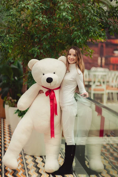 Hermosa chica sosteniendo un gran oso de peluche blanco — Foto de Stock