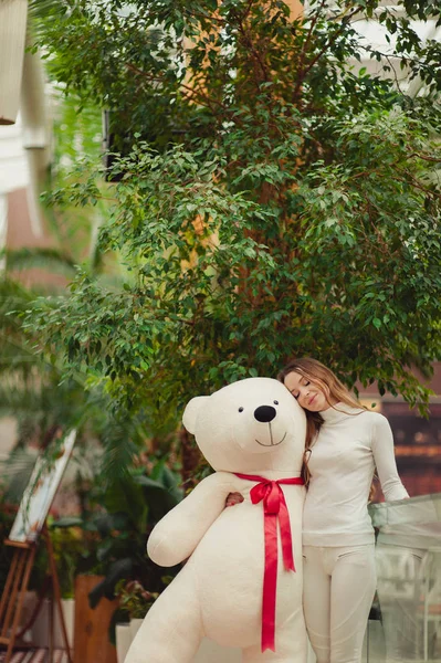 Vacker flicka håller en stor vit nallebjörn — Stockfoto