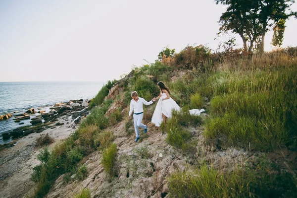 Beautiful wedding couple on a walk by the sea — Stock Photo, Image