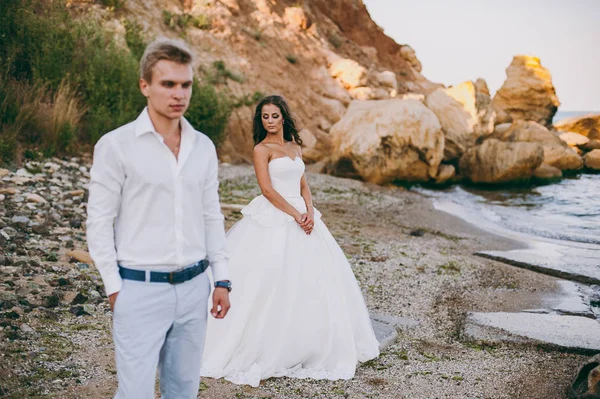 Schönes Hochzeitspaar auf einem Spaziergang am Meer — Stockfoto