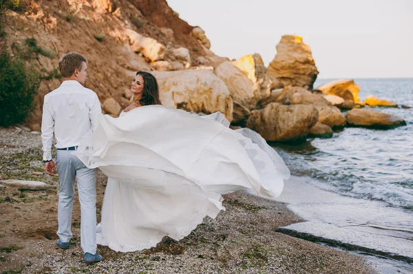 Beautiful wedding couple on a walk by the sea — Stock Photo, Image