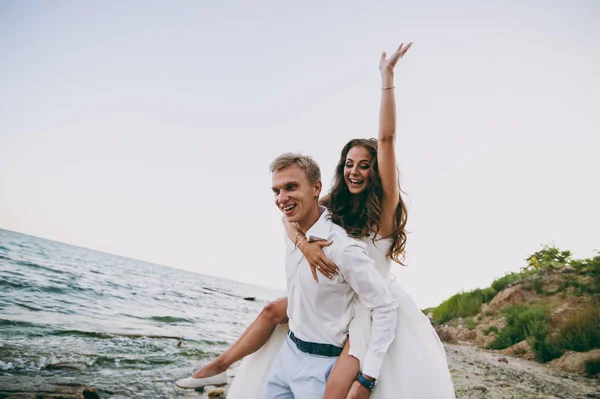 Hermosa pareja de boda en un paseo por el mar —  Fotos de Stock