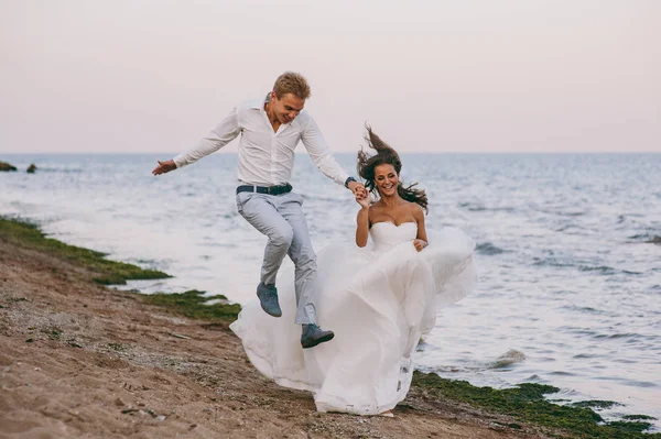 Hermosa pareja de boda en un paseo por el mar —  Fotos de Stock