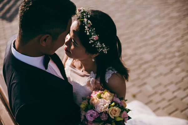 Dulce pareja de boda abrazándose en el paseo marítimo —  Fotos de Stock