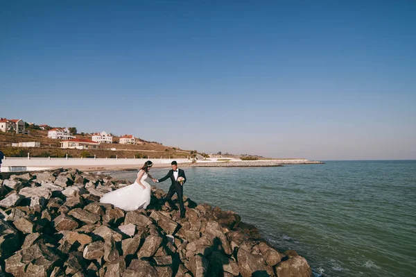 Ζευγάρι γάμος στην παραλία πάνω στα βράχια — Φωτογραφία Αρχείου