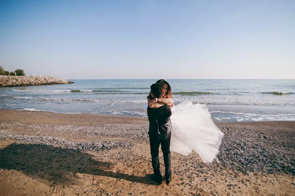 Casamento casal passeando ao longo da praia perto do mar — Fotografia de Stock