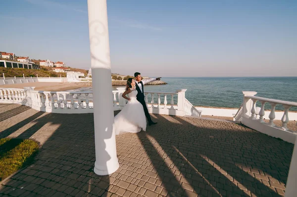 Hochzeitspaar bei einem Spaziergang auf dem Damm am Meer — Stockfoto