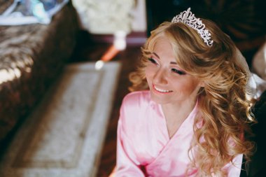 Taç güzel sarışın gelin bir sandalyede oturur