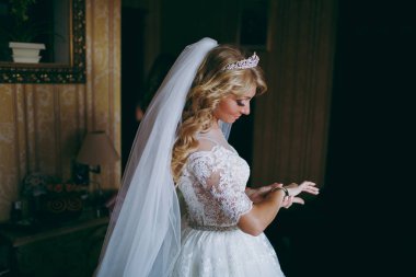 Güzel gelin sarışın bir bilezik kolunda koyar.