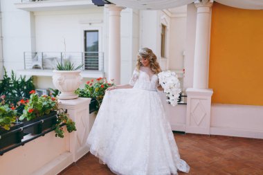 Bir buket çiçek ile güzel kıvırcık sarışın gelin