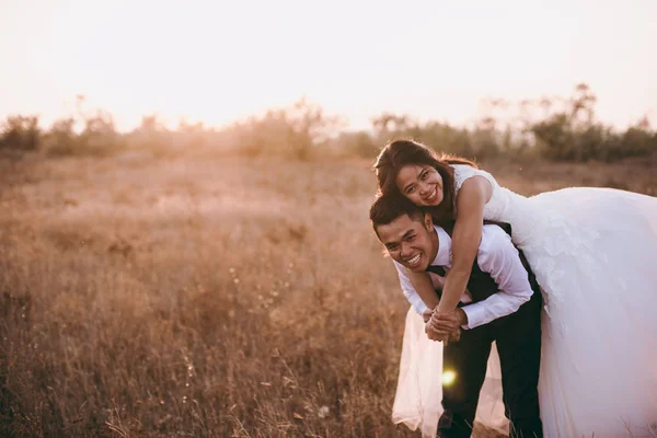 Wedding couple strolling in a valley with dry grass — Stock Photo, Image