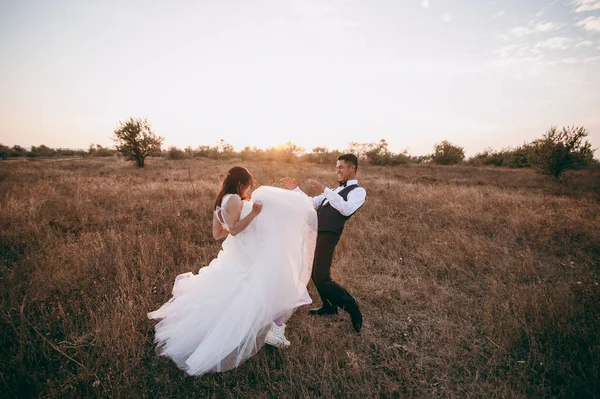 Pareja de bodas paseando en un valle con hierba seca —  Fotos de Stock