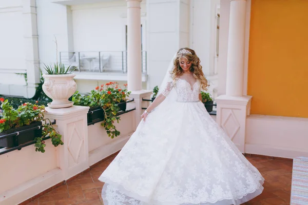 Schöne lockige blonde Braut mit einem Strauß Blumen — Stockfoto