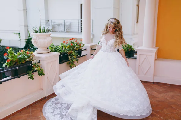 Schöne lockige blonde Braut mit einem Strauß Blumen — Stockfoto
