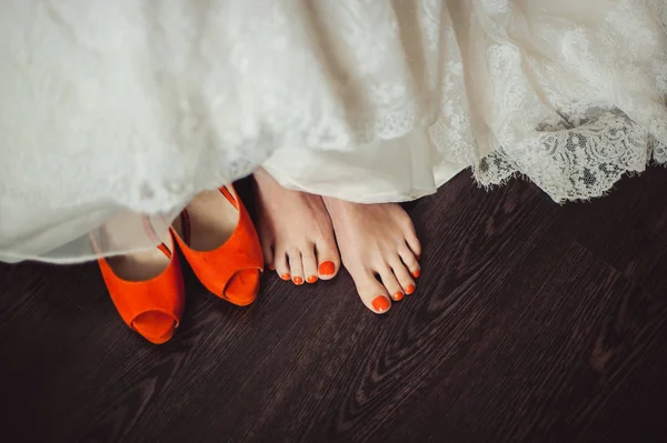 Ben av bruden med en orange pedikyr och orange sandaler — Stockfoto