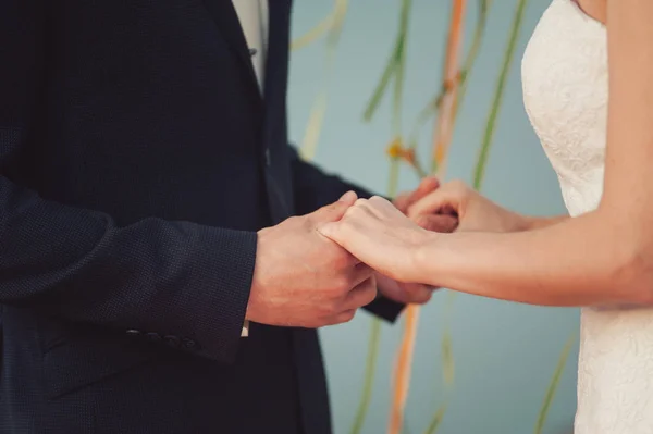 Жених и невеста держатся за руки на церемонии — стоковое фото